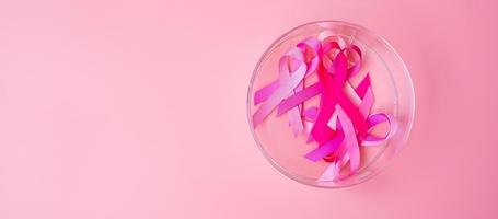 octubre mes de concientización sobre el cáncer de mama, cinta rosa sobre fondo rosa para apoyar a las personas que viven y están enfermas. concepto del día internacional de la mujer, la madre y el día mundial del cáncer foto