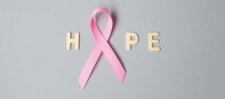 October Breast Cancer Awareness month, Pink Ribbon with HOPE text on grey background for supporting people living and illness. International Women, Mother and World cancer day concept photo