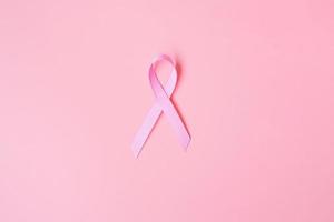 octubre mes de concientización sobre el cáncer de mama, cinta rosa sobre fondo rosa para apoyar a las personas que viven y están enfermas. concepto del día internacional de la mujer, la madre y el día mundial del cáncer foto