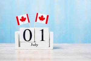 Wooden calendar of July 1st with miniature Canada flags. Canada Day  and happy celebration concepts photo