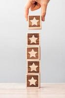 Man hand holding Star block. Customer choose rating for user reviews. Service rating, ranking, customer review, satisfaction, evaluation and feedback concept photo