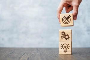 hand hold wood block with business goal, strategy, target, mission, action, objective, teamwork and idea concept photo