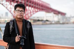 Happy man in coat and camera, Asian traveler enjoy and sightseeing view in the ship photo