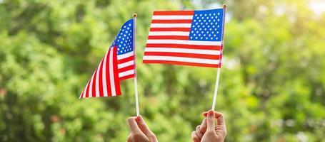 hand holding United States of America flag on green background. USA holiday of Veterans, Memorial, Independence  and Labor Day concept photo