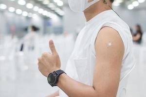 Happy man showing thumb after receiving vaccine. Vaccination, immunization, inoculation and Coronavirus pandemic photo