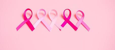 octubre mes de concientización sobre el cáncer de mama, cinta rosa sobre fondo rosa para apoyar a las personas que viven y están enfermas. concepto del día internacional de la mujer, la madre y el día mundial del cáncer foto