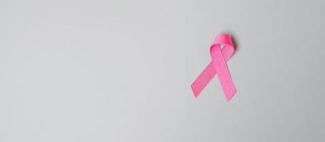 octubre mes de concientización sobre el cáncer de mama, cinta rosa sobre fondo gris para apoyar a las personas que viven y están enfermas. concepto del día internacional de la mujer, la madre y el día mundial del cáncer foto