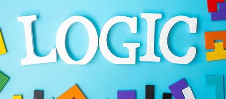 LOGIC text with colorful wood puzzle pieces, geometric shape block on blue background. Concepts of logical thinking, Conundrum, solutions, rational, strategy, world logic day and Education photo