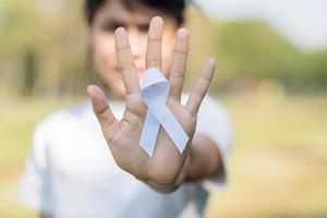 noviembre mes de concientización sobre el cáncer de pulmón, democracia y día internacional de la paz. mujer sosteniendo cinta blanca foto