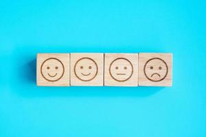 emotion face symbol blocks on blue background. Service rating, ranking, customer review, satisfaction, evaluation and feedback concept photo