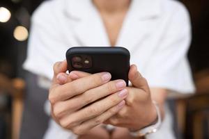 young Businesswoman holding and using smartphone for sms messages, man typing touchscreen mobile phone in office or cafe. business, lifestyle, technology and Social media network concept photo