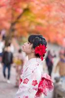 young woman tourist wearing kimono enjoying with colorful leaves in Kiyomizu dera temple, Kyoto, Japan. Asian girl with hair style in traditional Japanese clothes in Autumn foliage season photo