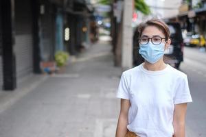 Woman wearing medical face mask during walking in street footpath and night market, prevent coronavirus or Corona Virus Disease. Health, life concept photo