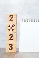 2023 Happy New Year with blank notebook and wooden number. countdown, Resolution, Goals, Plan, Action and Mission Concept photo