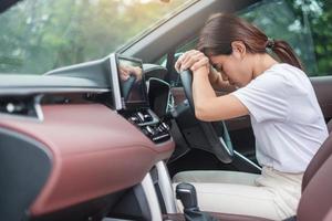 mujer sintiéndose estresada y enfadada durante mucho tiempo conduciendo el coche. chica asiática cansada y fatigada que deja de tener dolor de cabeza después de conducir un camión en un atasco de tráfico. concepto de sueño, estiramiento y borracho foto