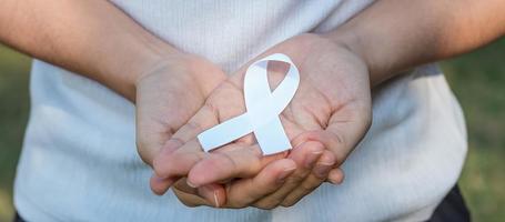 November Lung Cancer Awareness month, democracy and international peace day. Woman holding white Ribbon photo