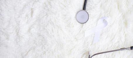 white Ribbon with stethoscope on white color background. November Lung Cancer Awareness month concept photo