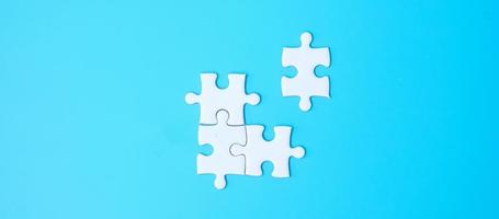 Group of white puzzle jigsaw pieces on blue background. Concept of solutions, mission, success, goals, cooperation, partnership, strategy and puzzle day photo