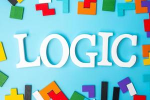 LOGIC text with colorful wood puzzle pieces, geometric shape block on blue background. Concepts of logical thinking, Conundrum, solutions, rational, strategy, world logic day and Education photo