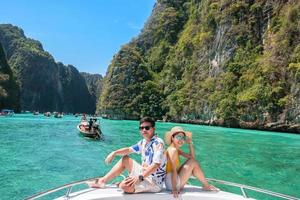 pareja de turistas en viaje en barco, viajero feliz relajándose en la laguna pileh en la isla phi phi, krabi, tailandia. exótico, luna de miel, amor, destino sudeste asiático concepto de viajes, vacaciones y vacaciones foto