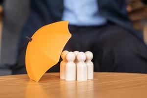 yellow umbrella cover man wooden from crowd of employees. People, Business, Human resource management, Life Insurance and Teamwork Concepts photo