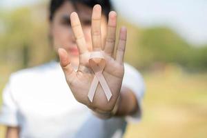 September Uterine Cancer Awareness month, woman hand holding Peach Ribbon for supporting people living and illness. Healthcare and World cancer day concept photo