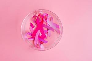 octubre mes de concientización sobre el cáncer de mama, cinta rosa sobre fondo rosa para apoyar a las personas que viven y están enfermas. concepto del día internacional de la mujer, la madre y el día mundial del cáncer foto