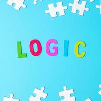 LOGIC text with white puzzle jigsaw pieces on blue background. Concepts of logical thinking, Conundrum, solutions, rational, strategy, world logic day and Education photo