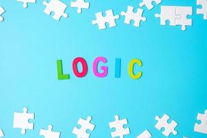 LOGIC text with white puzzle jigsaw pieces on blue background. Concepts of logical thinking, Conundrum, solutions, rational, strategy, world logic day and Education photo