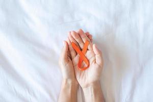 leucemia, día del cáncer de riñón, esclerosis múltiple mundial, crps, mes de concientización sobre autolesiones, cinta naranja para apoyar a las personas que viven y están enfermas. concepto de salud y día mundial del cáncer foto