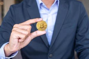 Businessman hand holding golden Bitcoin  cryptocurrency, Crypto is Digital Money within the blockchain network, is exchanged using technology and online internet exchange. Financial concept photo