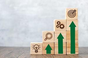 wood block stack of building with rise graph. business growth, goal, strategy, target, mission, action, success, teamwork, research and idea concept photo