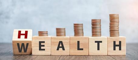 wooden block WEALTH to HEALTH with coins stack. Investment, Healthcare, Insurance and Work Life Balance concept photo