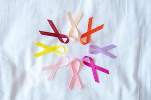 World cancer day. colorful awareness ribbons red, orange, purple, pink, peach and yellow color for supporting people living and illness. Healthcare and medical concept photo