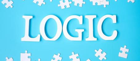 LOGIC text with white puzzle jigsaw pieces on blue background. Concepts of logical thinking, Conundrum, solutions, rational, strategy, world logic day and Education photo