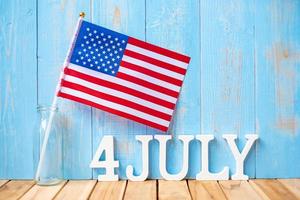 texto del cuatro de julio y bandera de los estados unidos de américa sobre fondo de mesa de madera. EE.UU. fiesta de la independencia y los conceptos de celebración foto