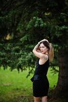 Portrait of gorgeous girl wear on black at hen party, posed at park. photo