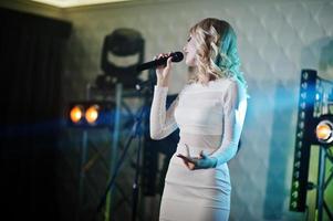 Beautiful blonde vocal singer girl on stage. photo