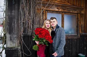 Loving couple in love at winter  day with large bouquet of 101 roses. photo