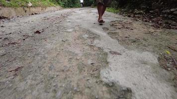 een man zonder schoenen loopt over een gebroken cementweg video