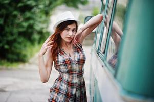 Amazing long legs with hig heels girl wear on hat against old retro minivan. photo