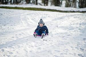 Cute little girl with saucer sleds outdoors on winter day. photo