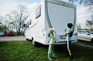 Children travel at motorhome RV camper van at parking. photo