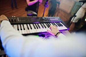 Hand of keyboardist on stage with lights. photo