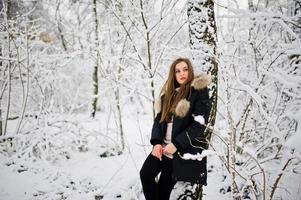 Beautiful brunette girl in winter warm clothing. Model on winter jacket. photo