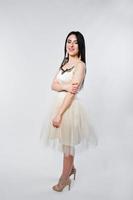 Portrait of brunette girl on beige dress isolated on white. photo