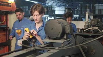 Multiracial professional industry engineer teams in safety uniforms work by inspecting machines' voltage current, checking, and maintaining at manufacture factory, electric system service occupations. video