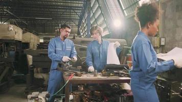 twee professionele teams van industriële arbeiders in veiligheidsuniformen en ingenieurspartners werkten met metaalbewerkingsgereedschappen, bespraken mechanisch tekenen voor draaimachines en een werkplaats in de productiefabriek. video