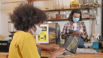 Two young cafe barista partners and entrepreneur work with face mask in coffee shop, waiting for customers order in new normal lifestyle service, SME business impact from COVID-19 pandemic quarantine. video