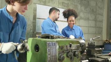 twee professionele teams van industriële arbeiders in veiligheidsuniformen en ingenieurspartners werkten met metaalbewerkingsgereedschappen, bespraken mechanisch tekenen voor draaimachines en een werkplaats in de productiefabriek. video